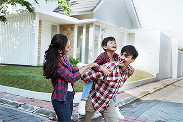 family playing carefree in front to their home